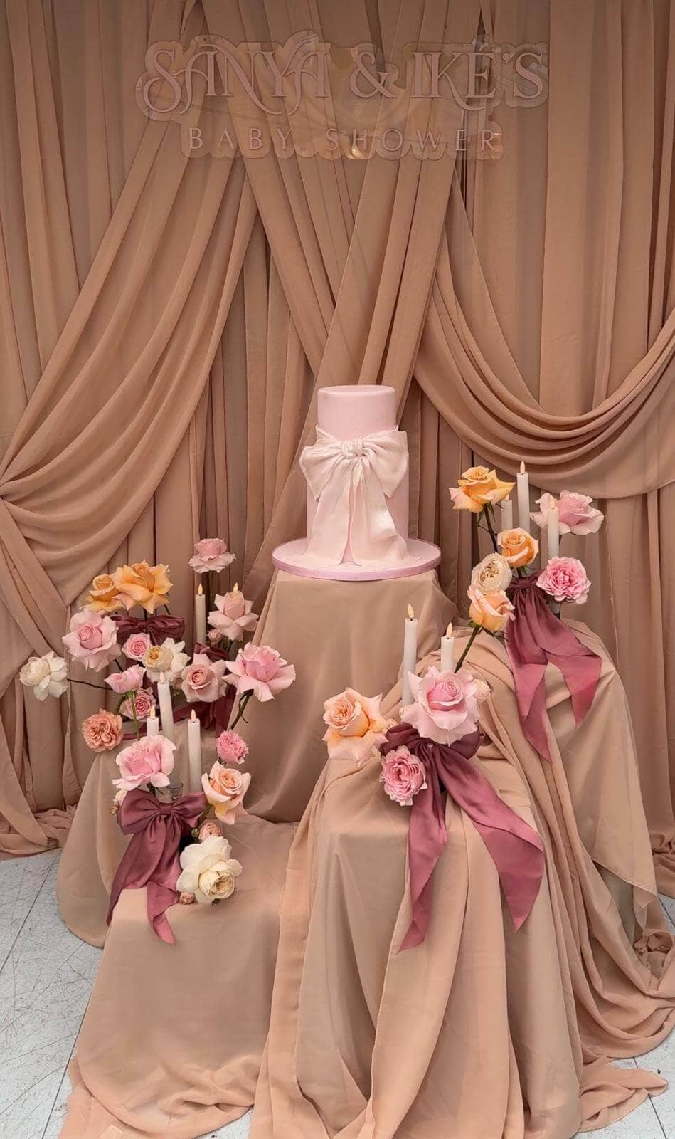 Beautiful baby shower cake display with pink and cream florals