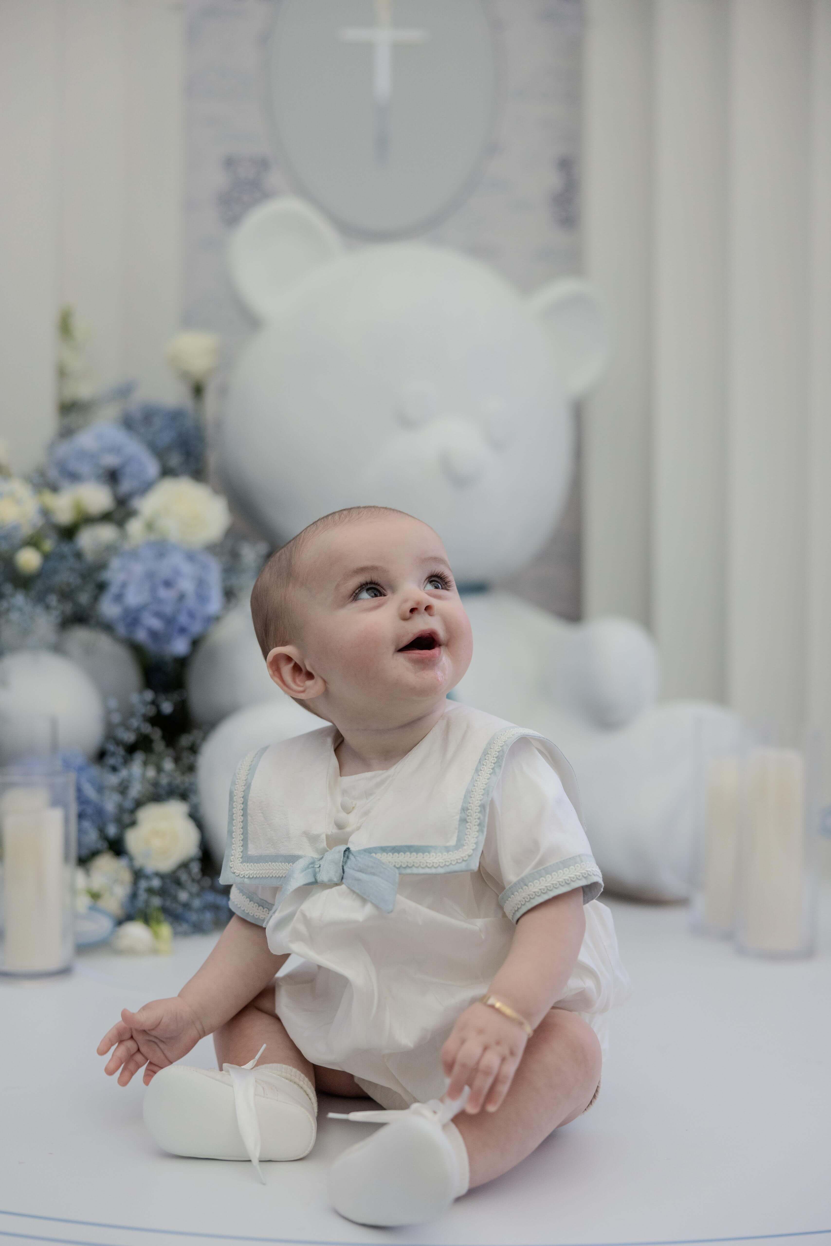 Elegant christening portrait with blue and white floral arrangements