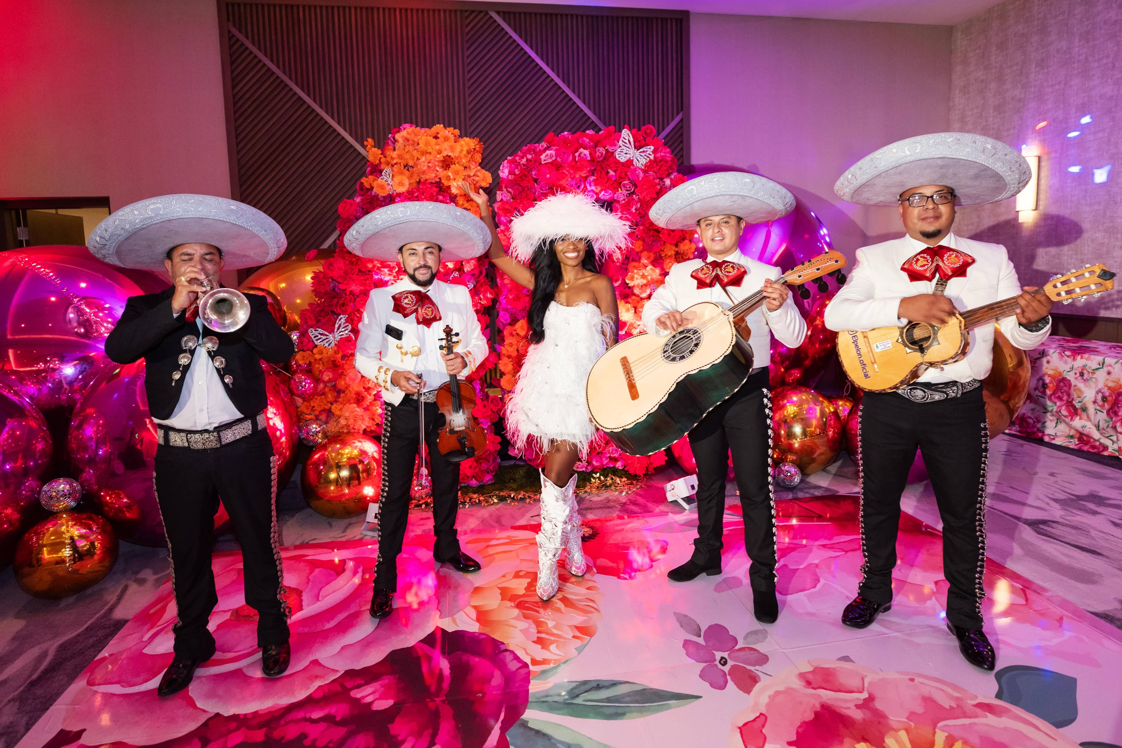 Vibrant mariachi band entertainment with orange and pink floral backdrop