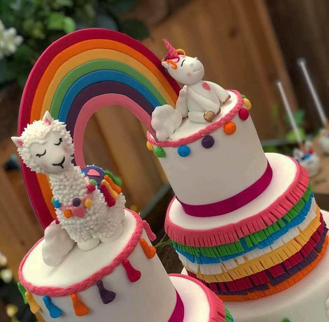 Whimsical rainbow birthday cake with llama and unicorn decorations
