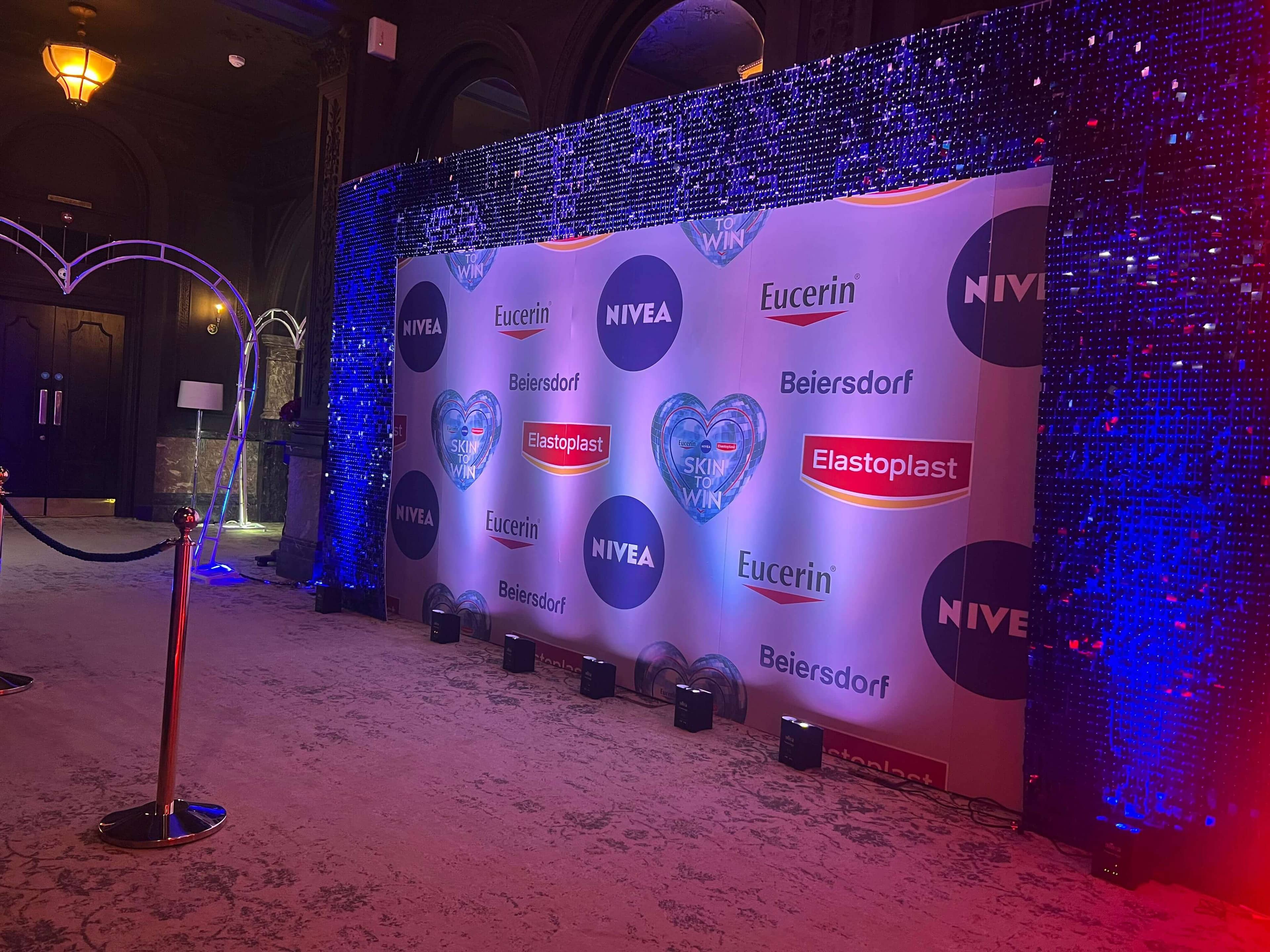 Sophisticated corporate event with branded backdrop and blue sequin curtains