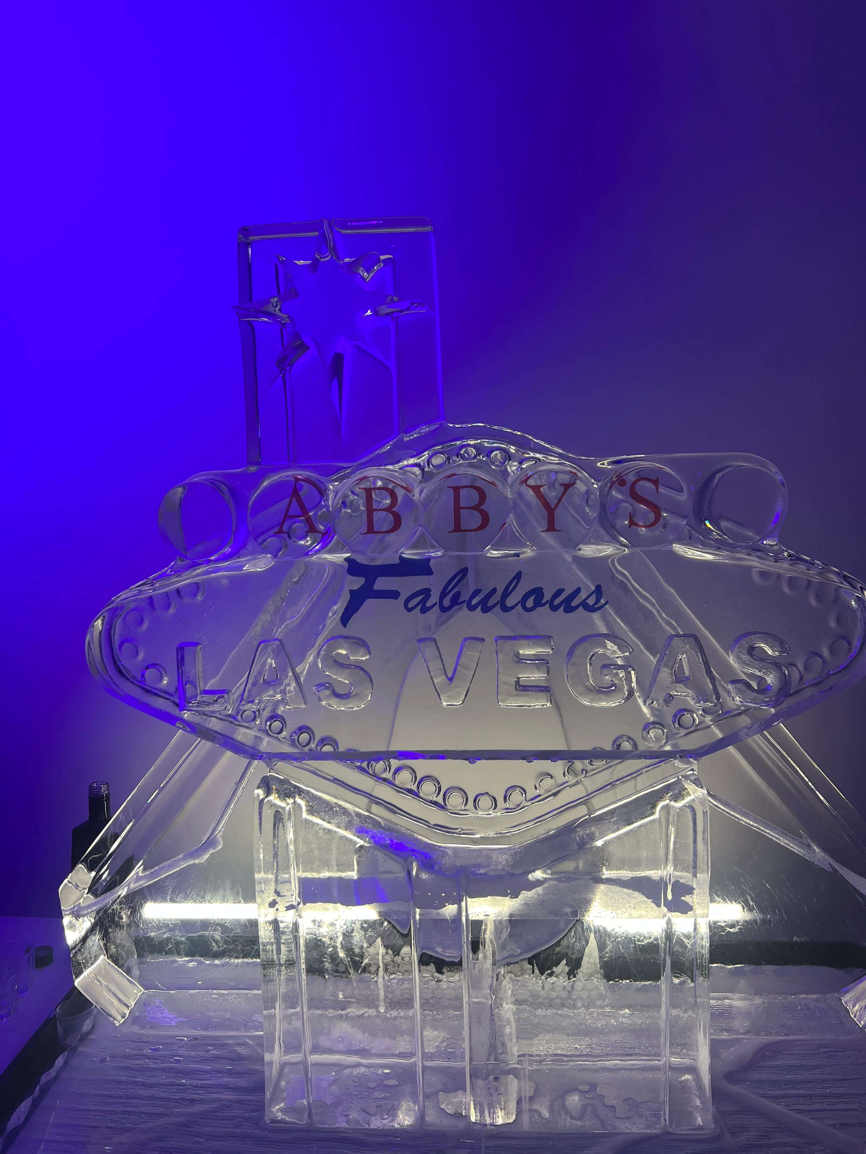 Las Vegas themed celebration with ice sculpture in purple-lit venue