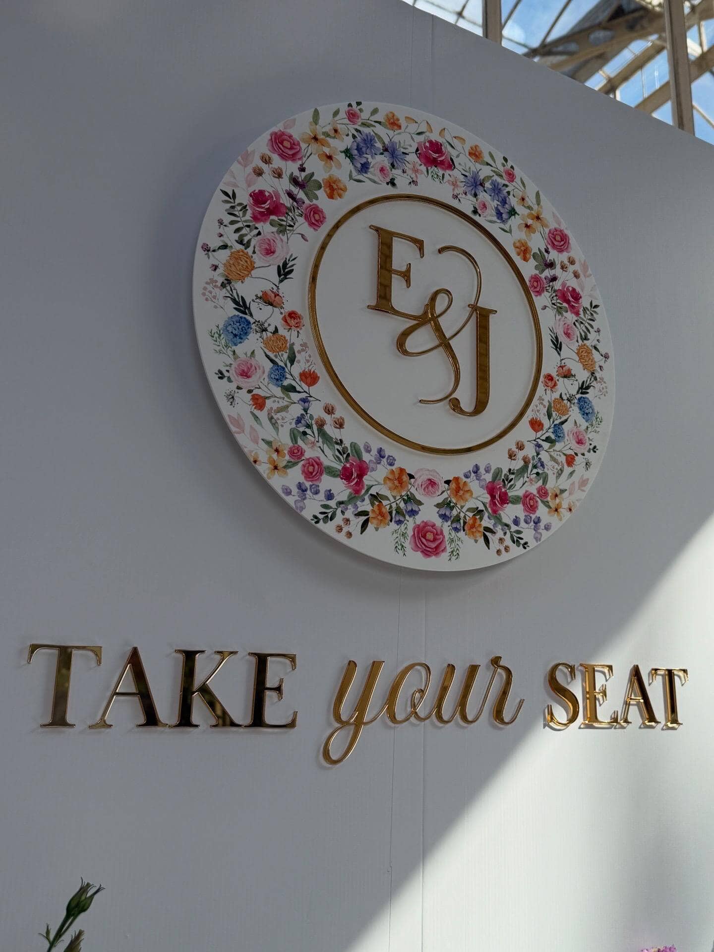 Elegant Take Your Seat display with floral monogram in conservatory