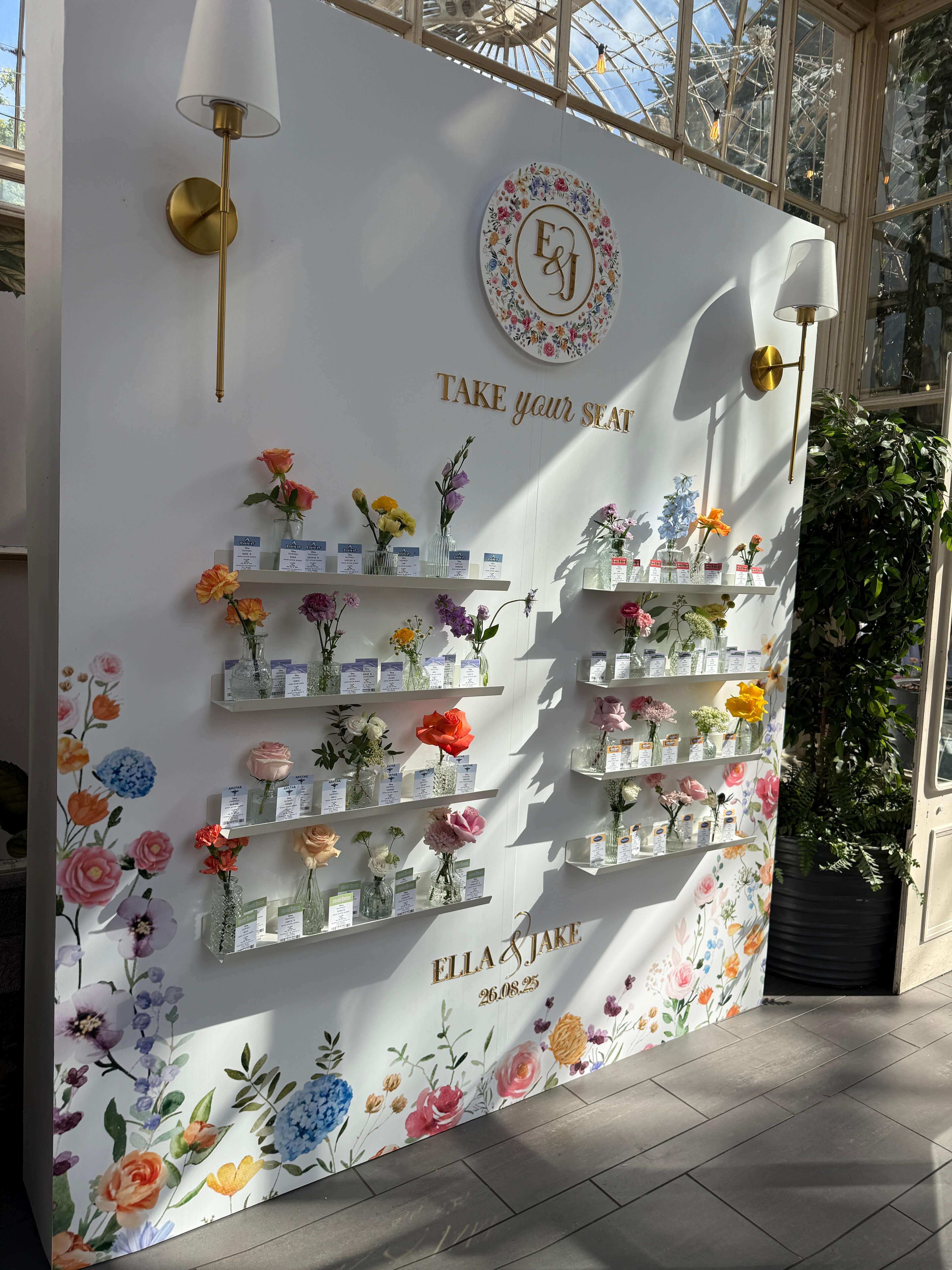 Beautiful conservatory escort card display with individual flowers in vases