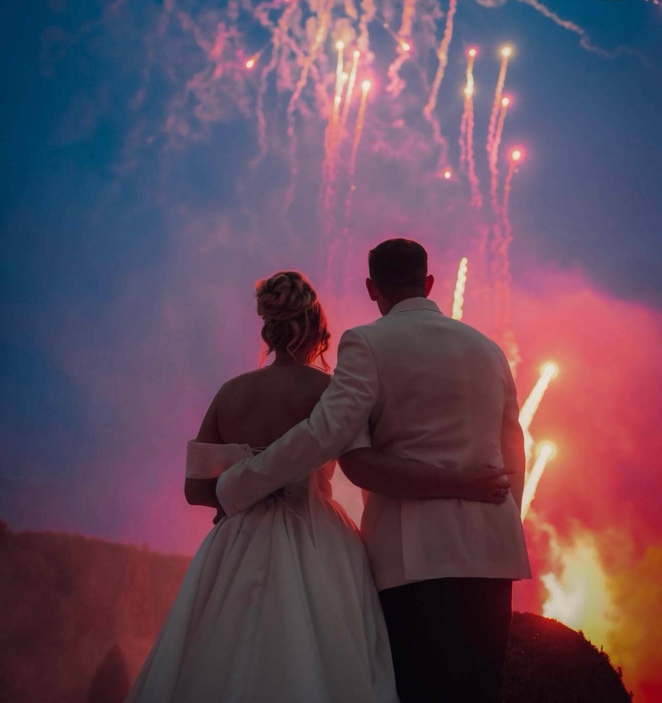 Romantic couple silhouette watching spectacular fireworks display at wedding
