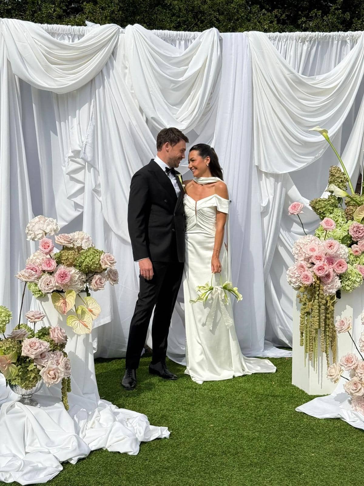 Elegant outdoor ceremony with white draping and pink floral arrangements